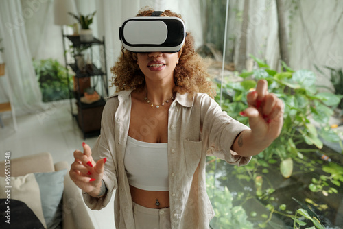 Young woman watching virtual reality in VR glasses