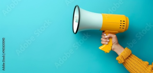 A vibrant hand holding a yellow megaphone against a blue background, symbolizing communication and announcement.