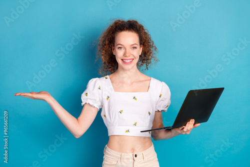 Photo portrait of attractive young woman hold netbook hold empty space dressed stylish white clothes isolated on blue color background