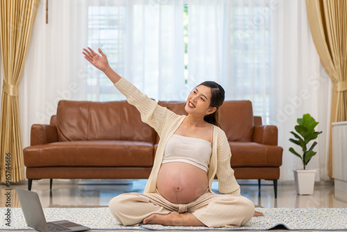 Pregnant asian woman practicing prenatal yoga at home, healthy pregnancy, maternity wellness, meditation and stretching, prenatal exercise routine, calm and relaxation, expecting mother in living room