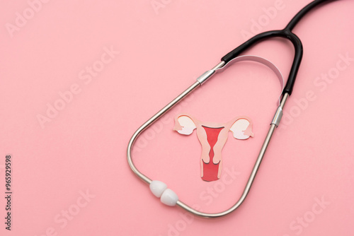 Medical Stethoscope Framing a Female uterus cutout on Pastel Pink Background, women's reproductive health and fertility