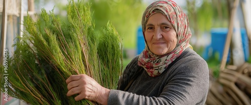 Elderly Eastern European Woman Holding Freshly Harvested Greens