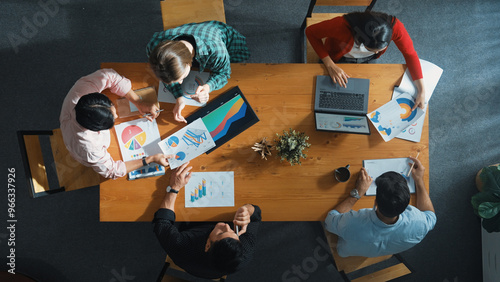 Top down view of manager holds tablet display increasing sales and placed on meeting table. Group of diverse business team clapping hands to celebrate successful product at meeting room Convocation.