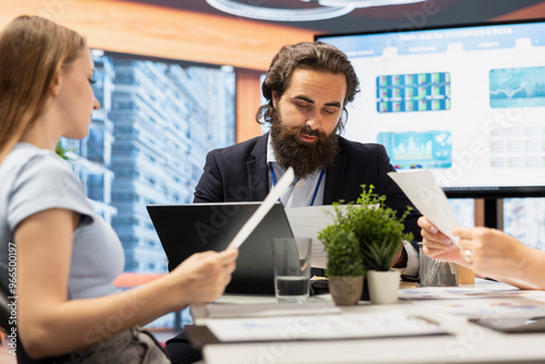 Portfolio Manager in office meeting analyzing economic reports, discussing with teenager wanting to receive student loan. Financial advisor helping young adult fund her education