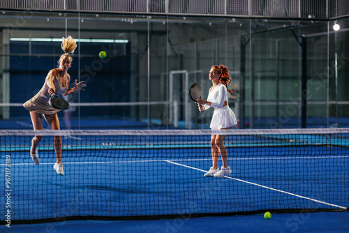 Two female padel teammates during a padel match point