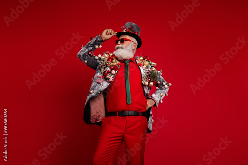 Photo of handsome eccentric man wear stylish suit summer glasses touch top hat empty space isolated on red color background