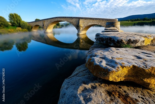 The Pont Saint-BÃ©nÃ©zet at dawn, with mist rising from the river and the ancient stone bridge emerging through the fog