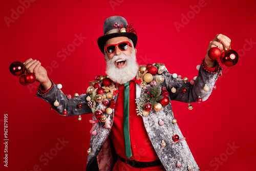 Photo of nice aged elegant man hold new year tree toys wear christmas tree balls costume sunglasses isolated red color background