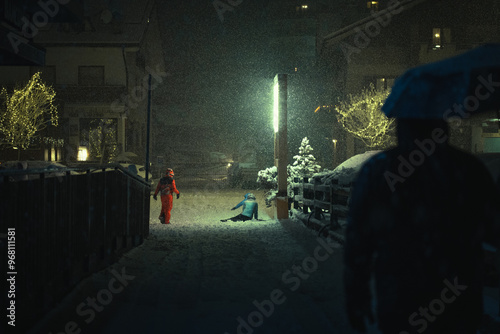 A group of children playing in the snow during a moody night in the city during a snowfall on New Years Eve, Aprica, Northern Italy