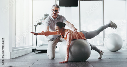 Ball, girl and personal trainer in gym for fitness, rehabilitation or stability training. Man instructor, woman or physiotherapy in yoga center for core strength, pilates practice or help in exercise