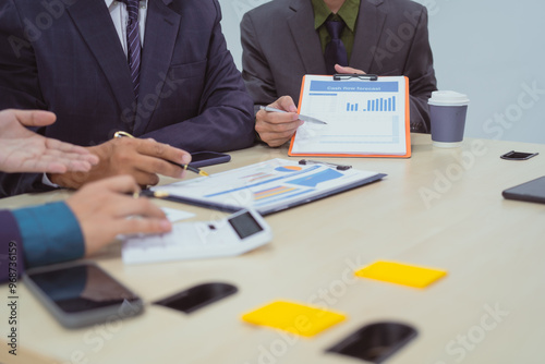  Close-up of a businessman in a meeting with a group of businessmen in the office, discussing digital marketing strategies, financial data analysis, and planning business projects together.