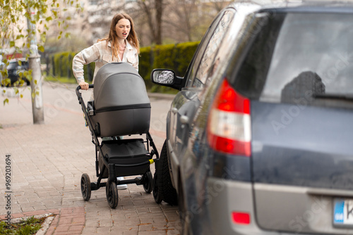 Young mother having a mishap while pushing baby stroller on sidewalk