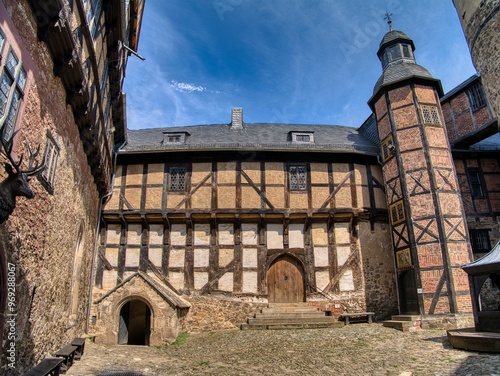 Historical half-timbered building with a stone courtyard, Falkenstein Castle in the Harz Mountains.