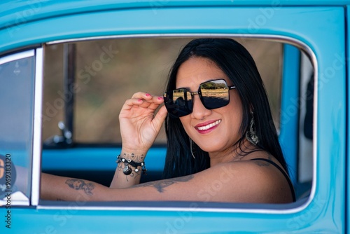 Woman smiling from a blue vintage car