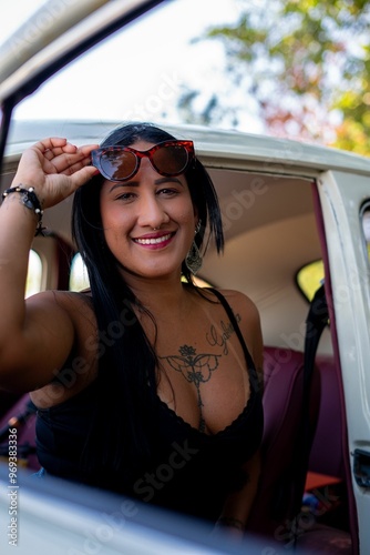 Smiling woman with sunglasses in a car.