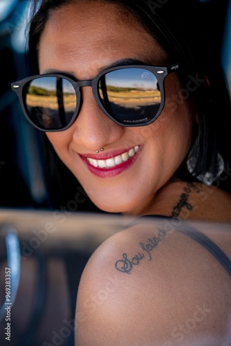 Smiling woman with sunglasses and tattoo