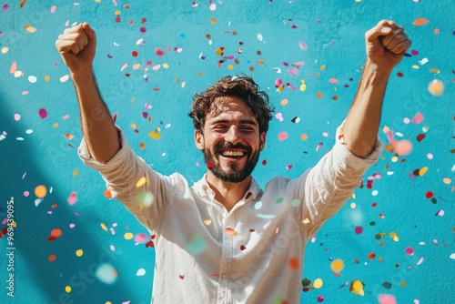 Man celebrating with raised arms and confetti.