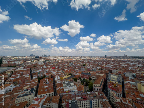 panoramiczny widok na Madryt stolicę Hiszpanii. Widać ogromne zróżnicowanie architektoniczne budynków, główne ulice i pięknie zachmurzone niebo