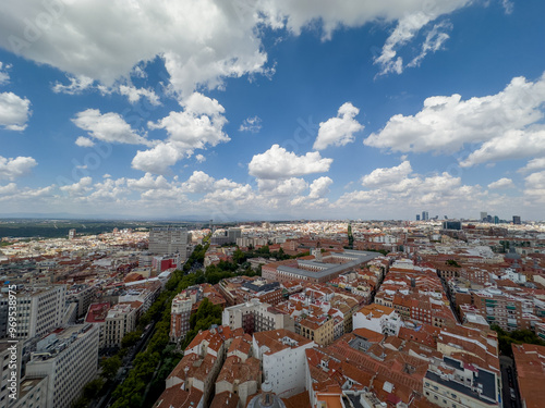 panoramiczny widok na Madryt stolicę Hiszpanii. Widać ogromne zróżnicowanie architektoniczne budynków, główne ulice i pięknie zachmurzone niebo