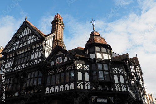 Old half timbered buildings on the corner of Eastgate and bridge street with stairs leading to the upper rows in Chester