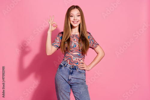 Photo of adorable optimistic girl with straight hairdo wear print t-shirt showing good work okey isolated on pink color background