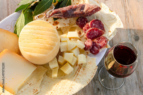 Pecorino, salsiccia secca di maiale, pane carasau e calice di cannonau, gastronomia sarda, cibo italiano 