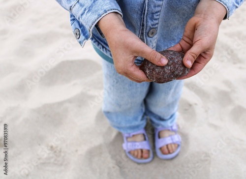 little boy holding a stone on the beach