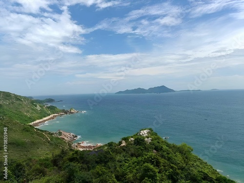 Scenic coastal view with lush green hills and distant islands.