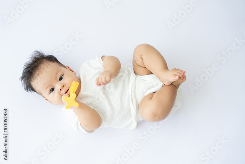 a baby laying on the floor with a paco in his mouth