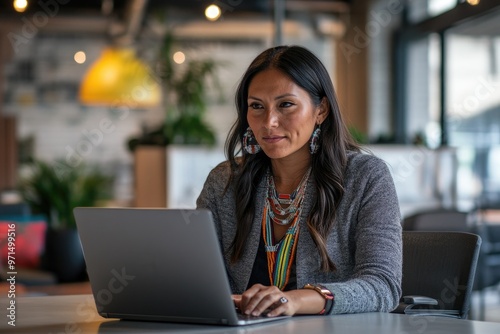 Native American female entrepreneur in modern office using laptop, remote job and education