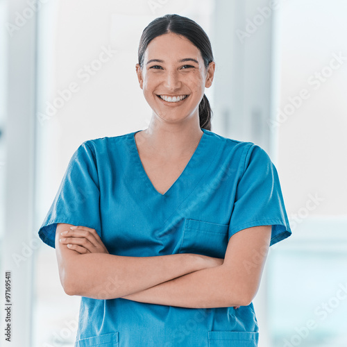 Portrait, nurse and happy woman with arms crossed for healthcare career, pride and service in hospital. Face, smile and confident medical professional, employee and expert surgeon working in Spain