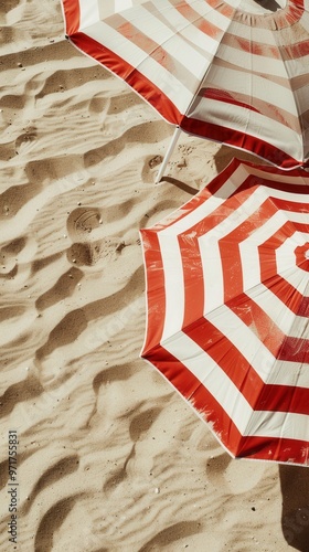 Closeup of beach umbrellas with bright stripes, standing tall on the sand..