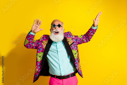 Portrait of overjoyed aged man star shape sunglass enjoy dancing isolated on yellow color background