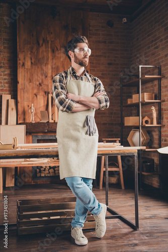 Photo of professional serious woodworker guy standing with crossed hands look profile side in garage