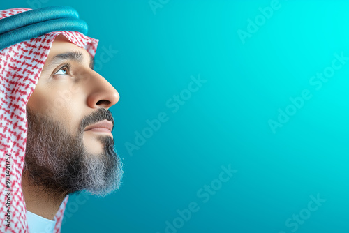 Man in traditional attire gazing upwards against a blue backdrop