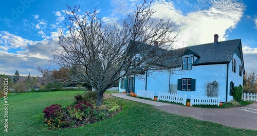 Anne of Green Gables Heritage Place in Cavendish, Prince Edward Island, Canada that features a historic blue house with green trim, surrounded by lush gardens under a vast sky.