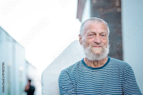 Portrait of an elderly man smiling in the park during his leisure time. This mature gentleman exudes serenity and happiness, showcasing a healthy and fulfilling lifestyle while embracing the joys 