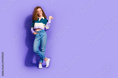 Full size photo of nice young girl indicate fingers empty space isolated on violet color background