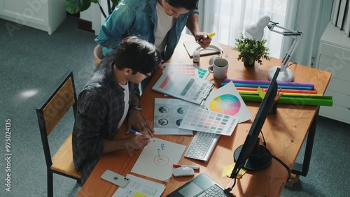 Top view of project manager looking at screen while designer writing idea. Close up of smart business team explain idea of logo design while designer choose theme while looking at palette. Symposium.