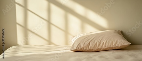 A serene bedroom scene featuring a soft pillow on a bed, illuminated by gentle sunlight casting intricate shadows.