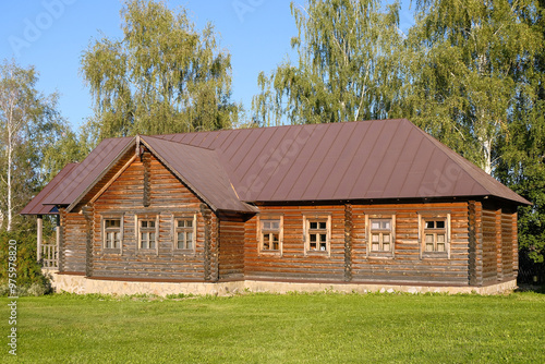 Old traditional Russian wooden house izba on a sunny summer day.