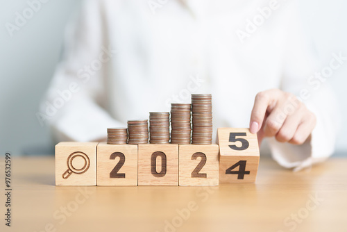 2024 end year to Happy New Year 2025 with coins money stack growing with magnifier glass. Money saving, Inflation, tax, cash flow, Job search, hiring and research development concepts