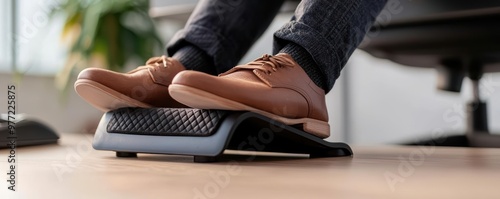 A close-up of feet on a footrest in an office setting, emphasizing comfort and ergonomics while working at a desk.