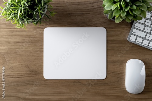 On a white wooden desk with a mouse, keyboard, and a potted succulent, an elegant mousepad mockup, a minimalist workspace template for your product.