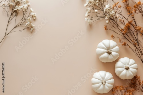 A minimalist flat lay display featuring handmade plaster pumpkins and dried flowers on a beige background, perfect for autumn and Halloween decor ideas