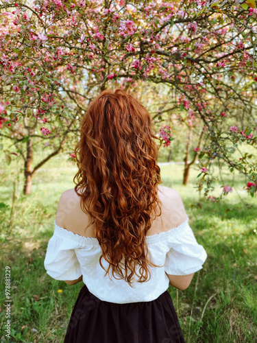 Blooming apple tree and a wavy ginger haired girl