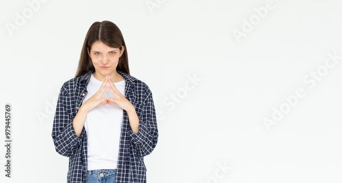 I have great evil plan. Confident and tricky woman in blue shirt, holding fingers together and smirking at camera, having some bad intention in mind, planning to commit crime