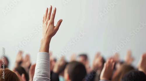 A close-up of a raised hand in a crowd, symbolizing participation, engagement, volunteering, or asking questions in a group setting such as a classroom, meeting, or seminar.