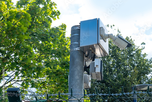 Security cameras mounted on pole with barbed wire and blue sky background, surveillance cameras overlooking restricted area, ensuring perimeter safety