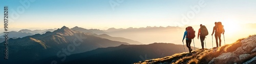 hikers trekking in mountain range during sunset